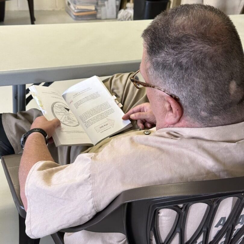 A man sitting at the table reading a book.